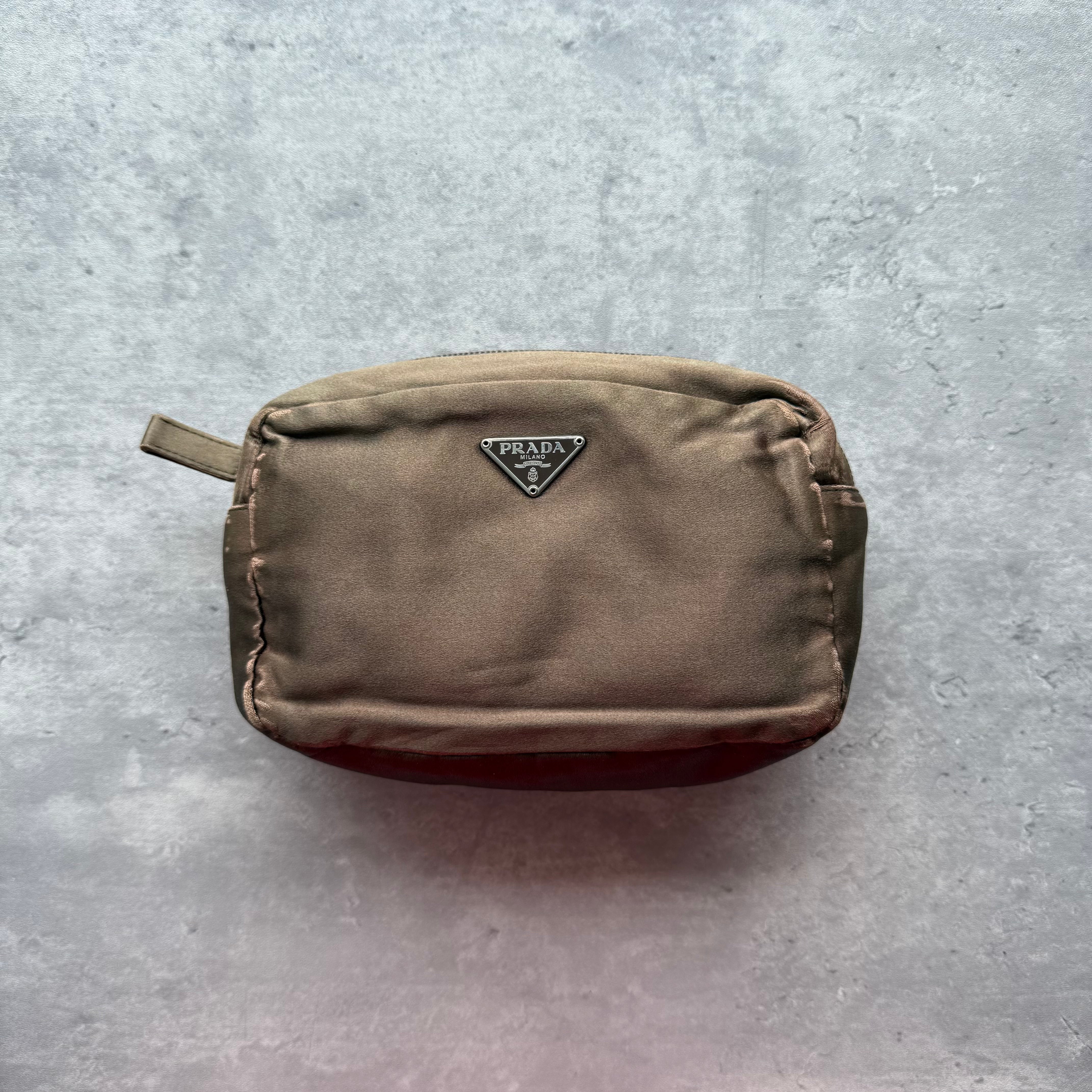 Prada Tessuto Pouch in brown with triangular logo plaque and zip closure.