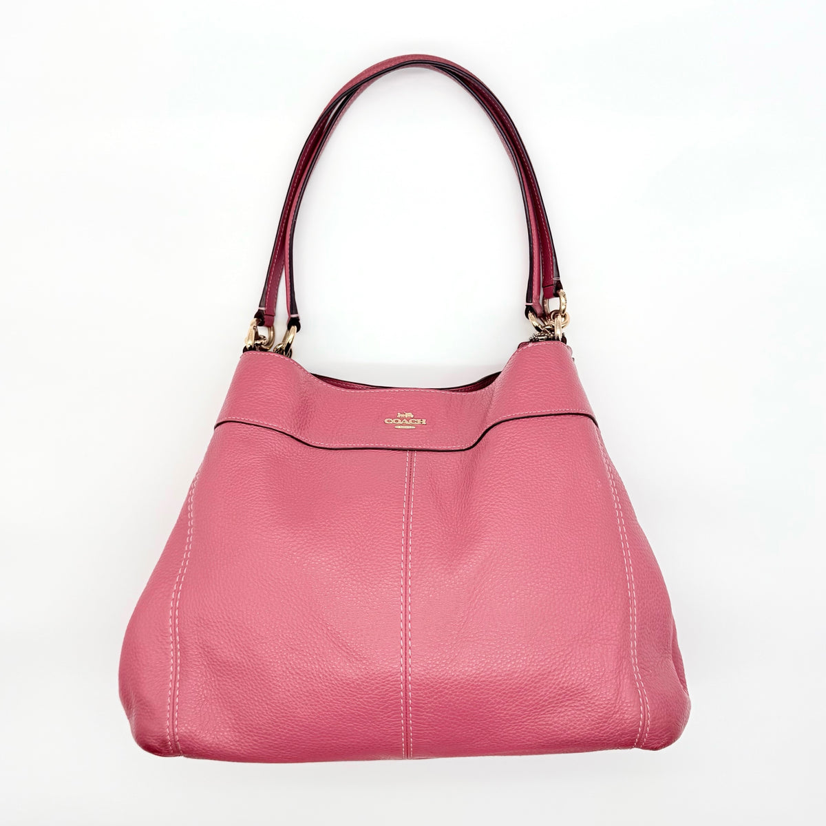 Coach Lexy Shoulder Bag in pink pebbled leather with gold hardware and dual straps, shown against a white background.