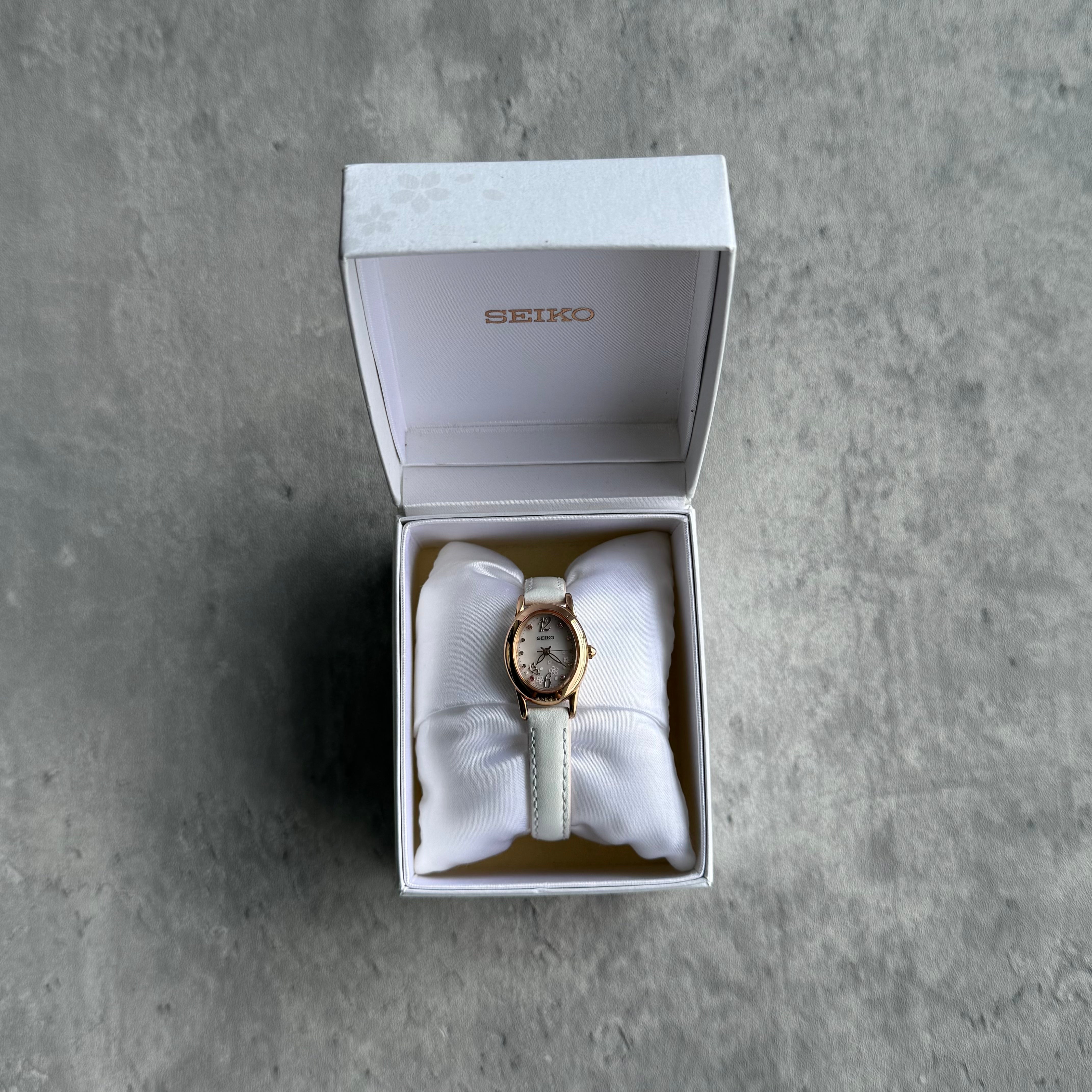 Seiko Sakura Blooming Limited Edition watch with rose gold case, white leather strap, and floral-inspired dial.