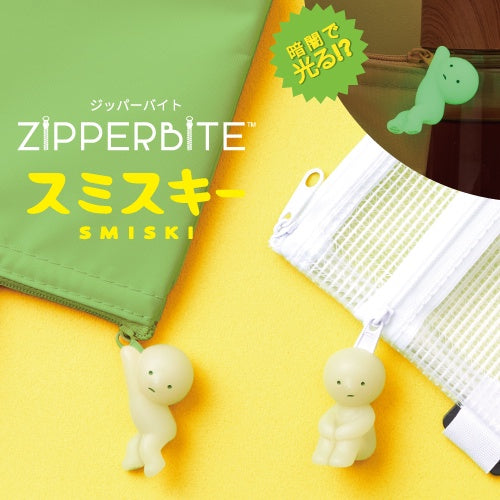 Smiski ZipperBite accessories glowing in the dark and clipped onto zippers, featuring soft vinyl Smiski figures in playful poses