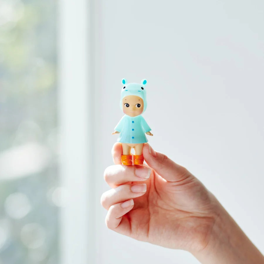 Sonny Angel I Love Rainy Day Series mini figures wearing colorful animal-themed raincoats and boots, displayed with flowers and soft background decor.