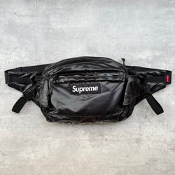 Supreme Waist Bag Black, crafted from ripstop nylon with front box logo and reflective Supreme branding, adjustable strap and multiple compartments.