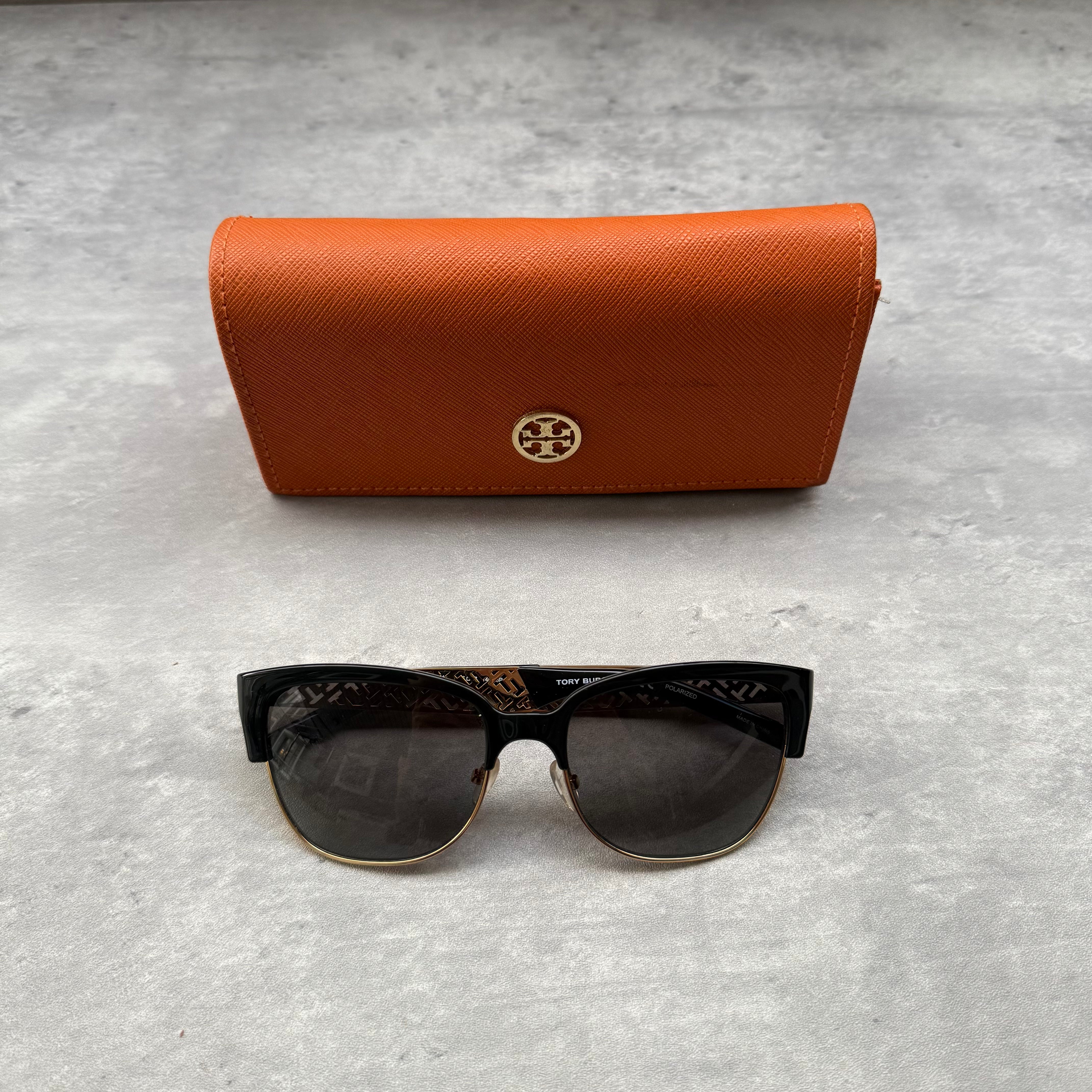 Tory Burch Sunglasses in gold and black with logo-engraved temples and black tinted lenses.