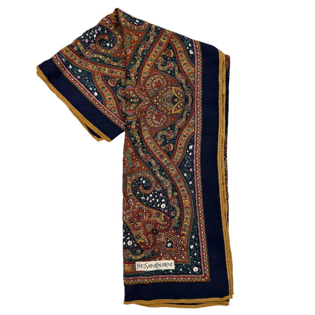 A Saint Laurent cotton scarf in multicolour paisley, elegantly folded to reveal its intricate pattern and ochre border.