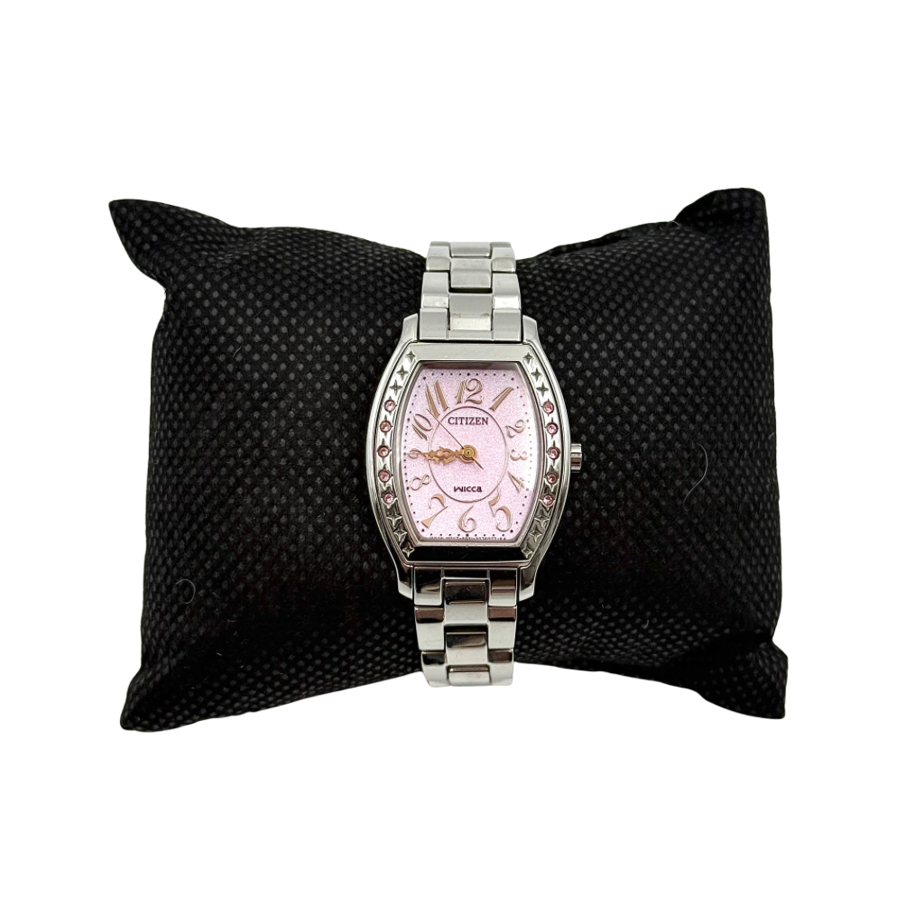 Citizen Wicca stainless steel watch with pink dial and star-detailed bezel shown on a black cushion.