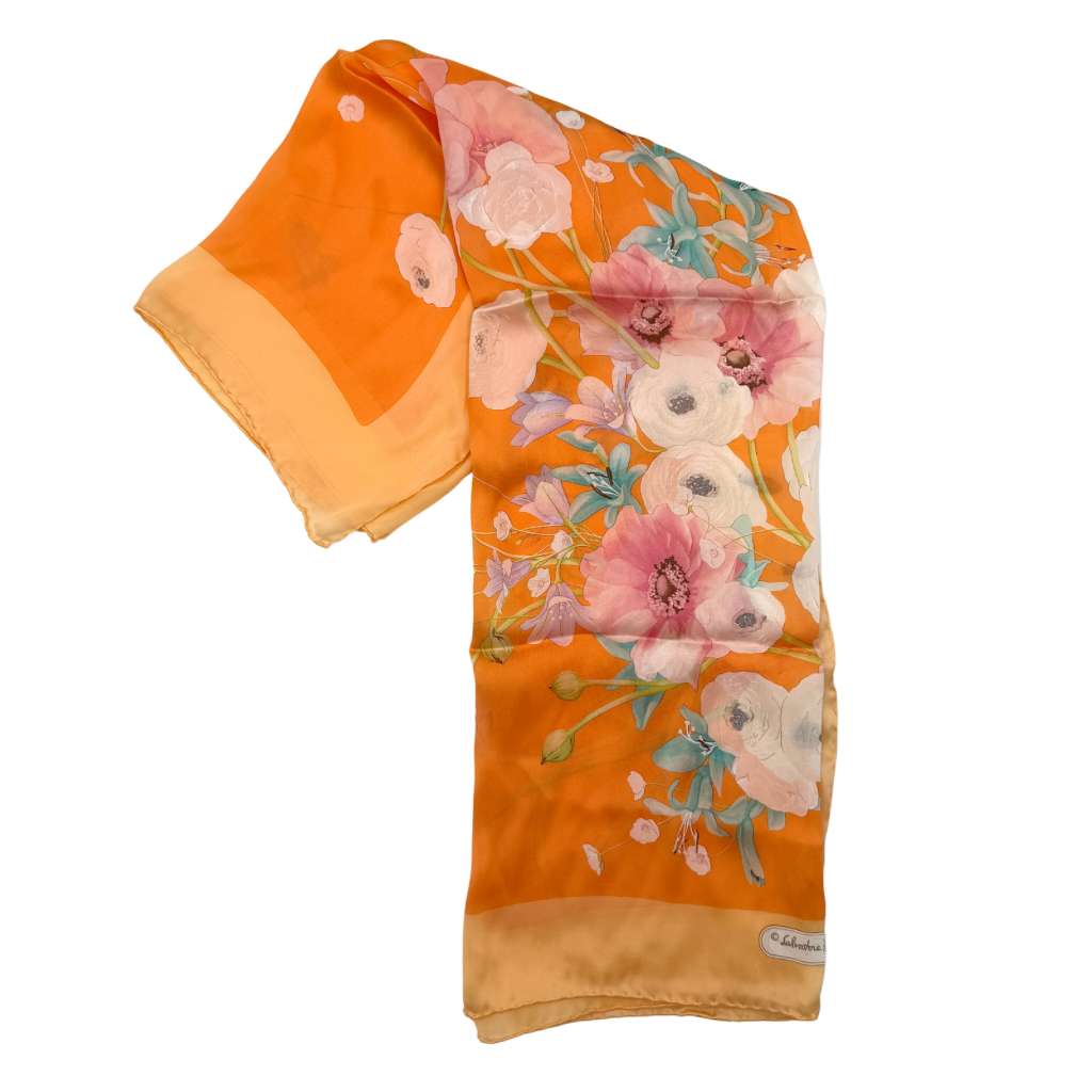 An orange Salvatore Ferragamo silk scarf with pastel floral print displayed in a gentle drape.