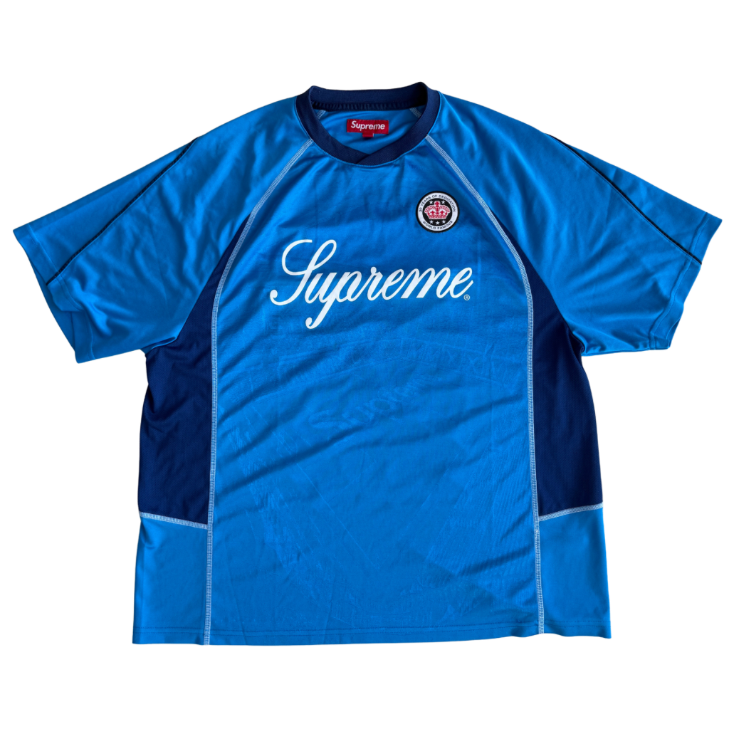 Supreme Jacquard Soccer Jersey in blue with front Supreme script and patch, navy side panels, and sporty detailing.