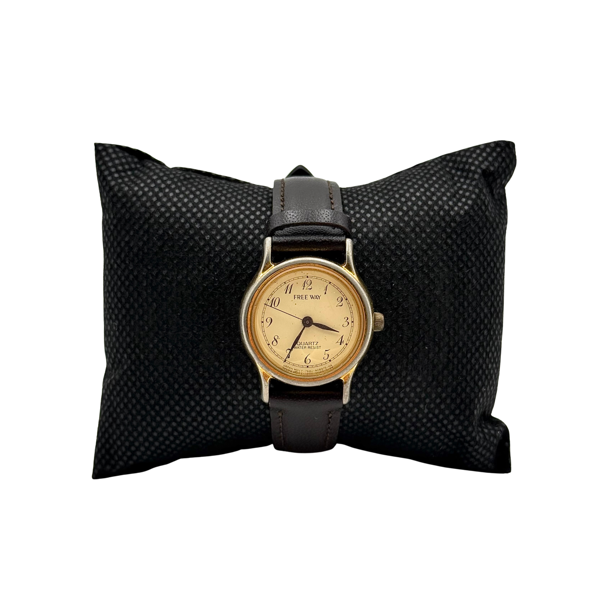 Citizen Freeway gold-tone quartz watch with black leather strap on a textured cushion