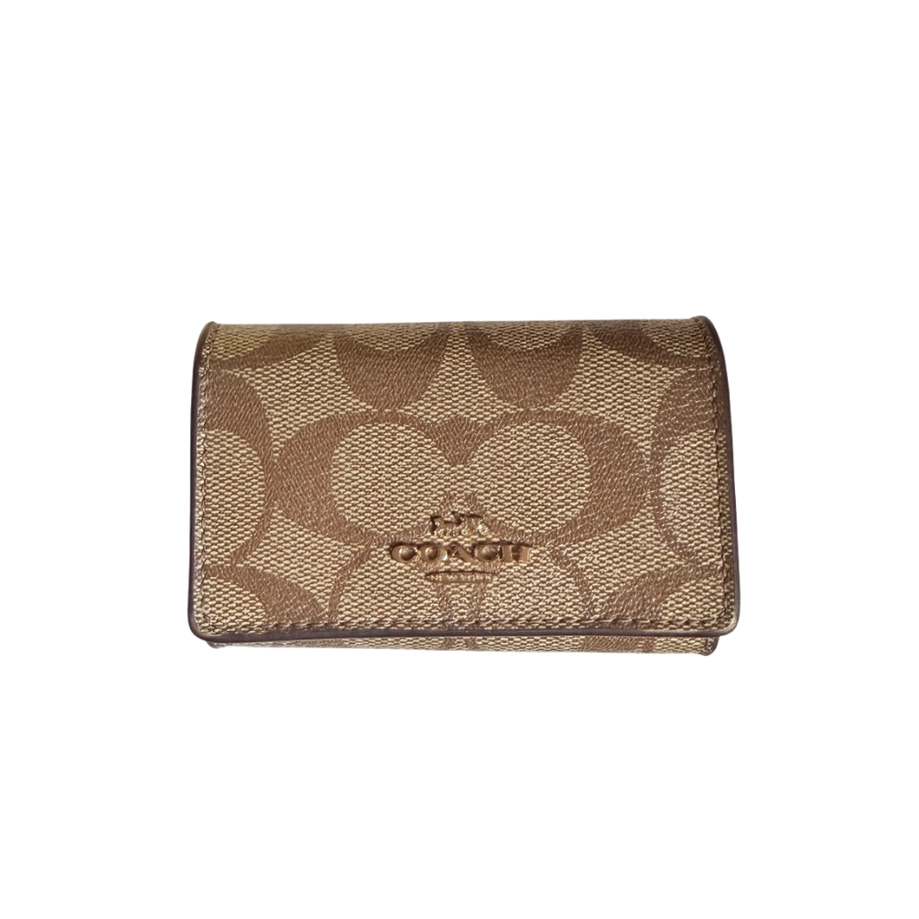 Coach Signature Canvas Key Case in beige with gold-tone logo and signature monogram pattern, shown in a front view.