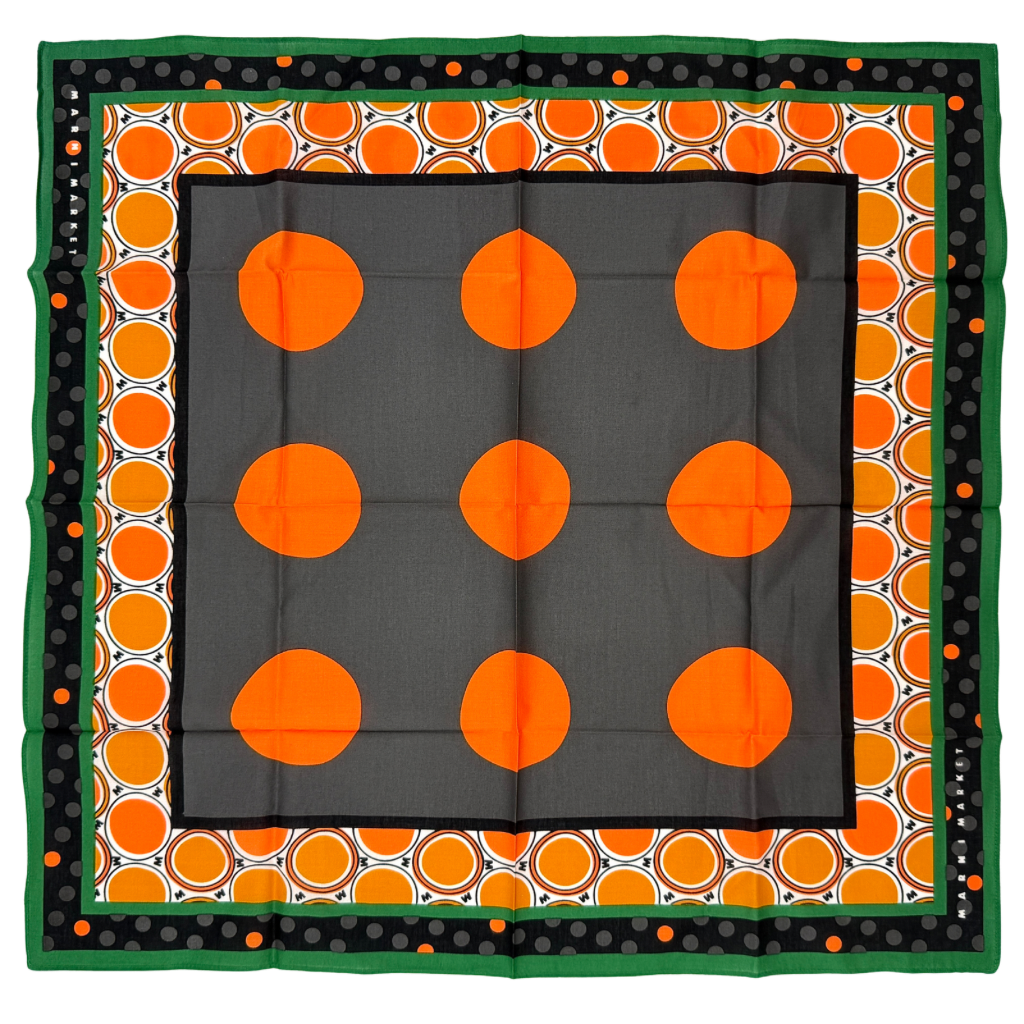 A Marni Market square scarf in orange polka dots and geometric borders with green edges, neatly laid out to show its graphic pattern.