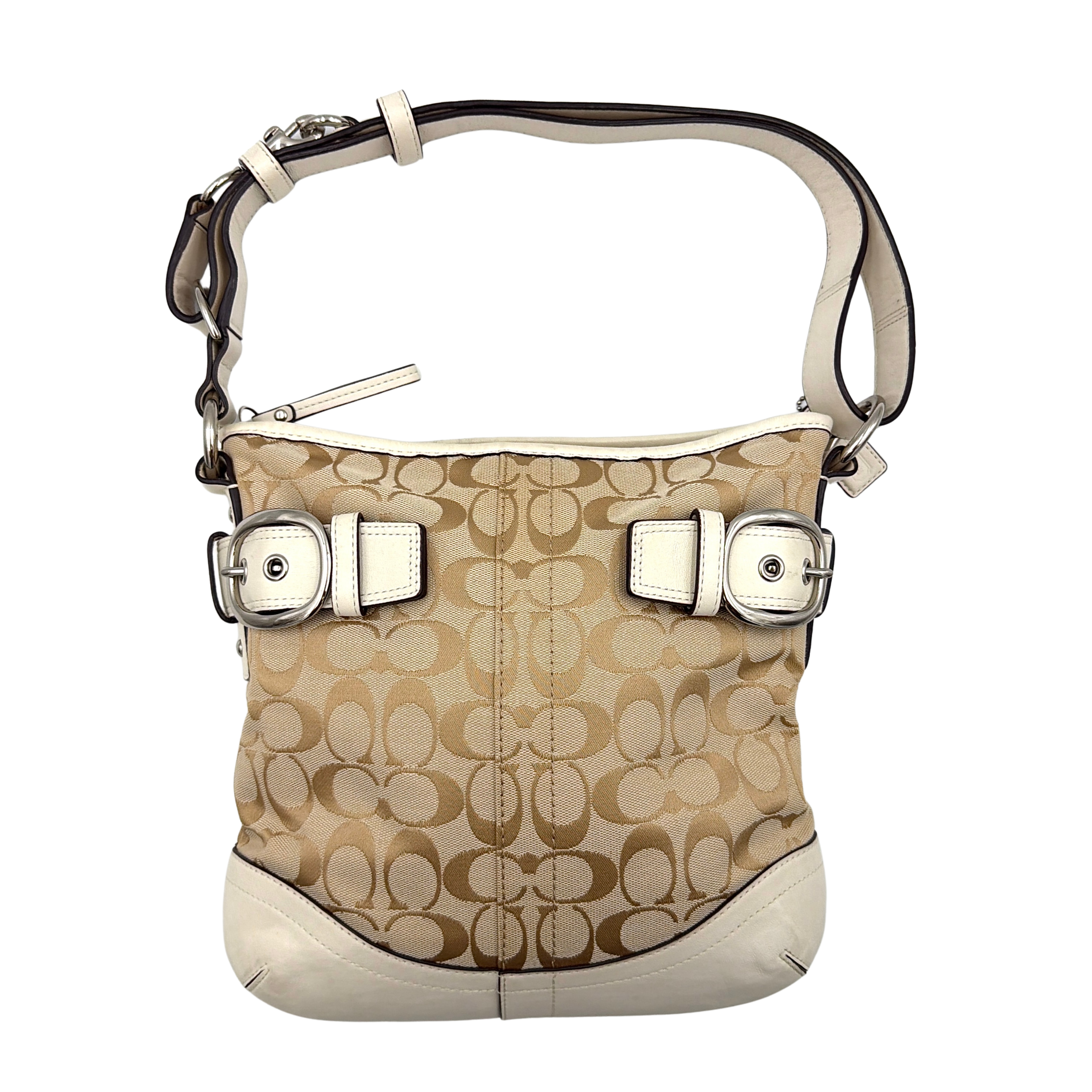 Coach beige and white signature canvas shoulder bag with white leather trim, silver buckles, and adjustable strap on display.