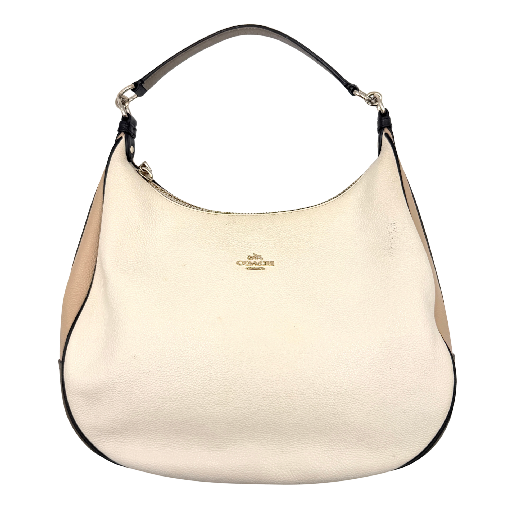 Coach Harley East West Hobo in cream and beige pebbled leather with a sculpted silhouette, black piping, and silver hardware.