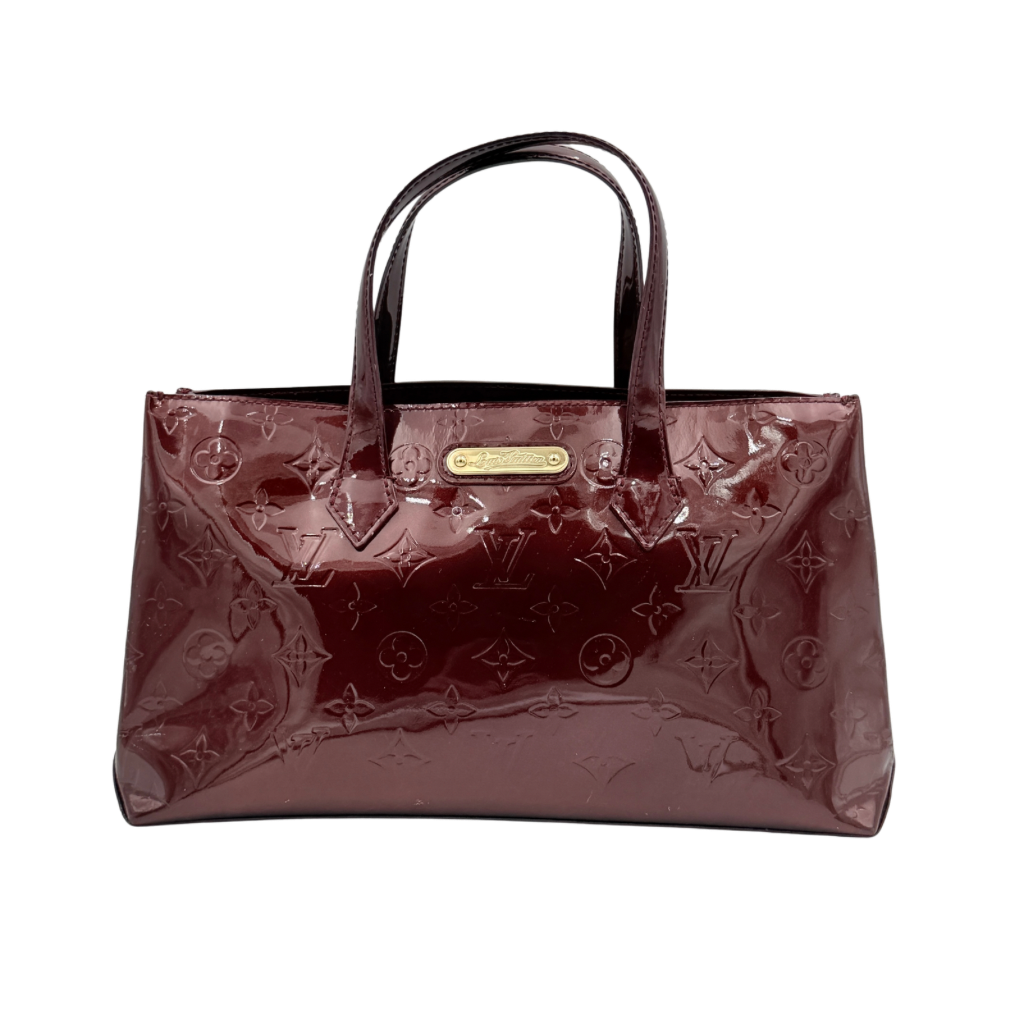 Louis Vuitton Wilshire PM Monogram Vernis bag in glossy deep red with gold nameplate and embossed monogram, displayed against a clean background.