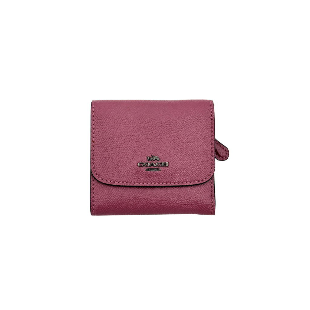 Coach small wallet in pink pebbled leather with silver logo hardware, presented closed and front-facing.