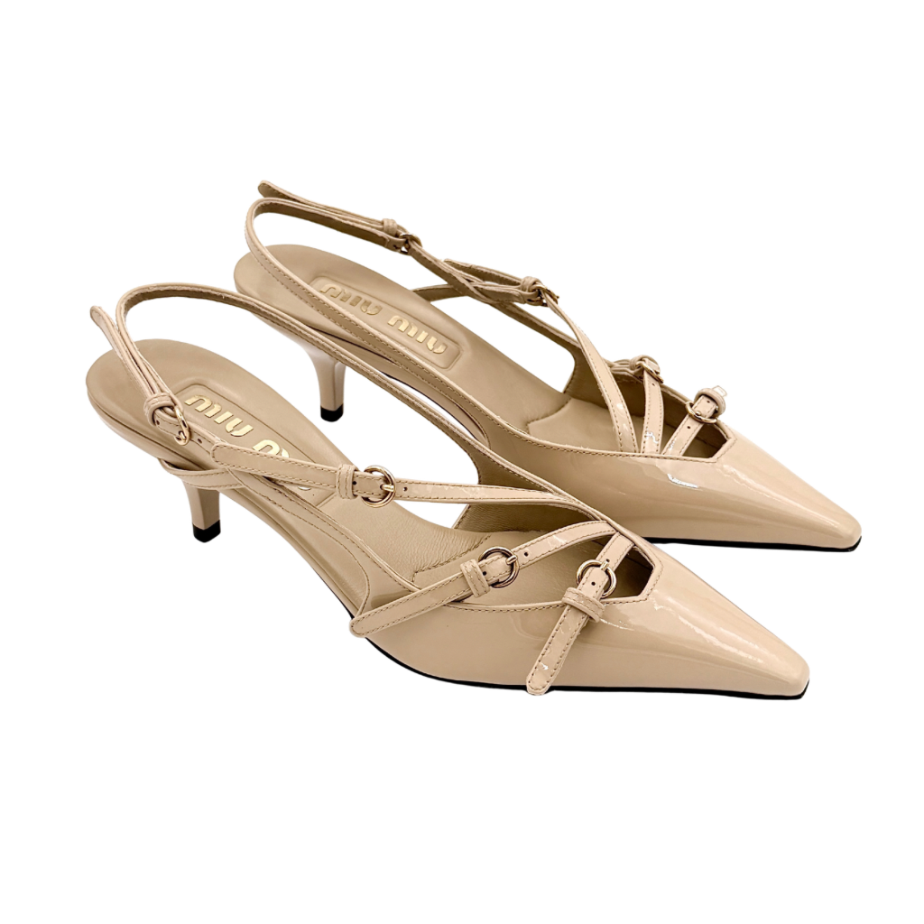 A pair of Miu Miu beige patent leather slingback pumps with pointed toes and gold-tone buckles displayed on a white background.