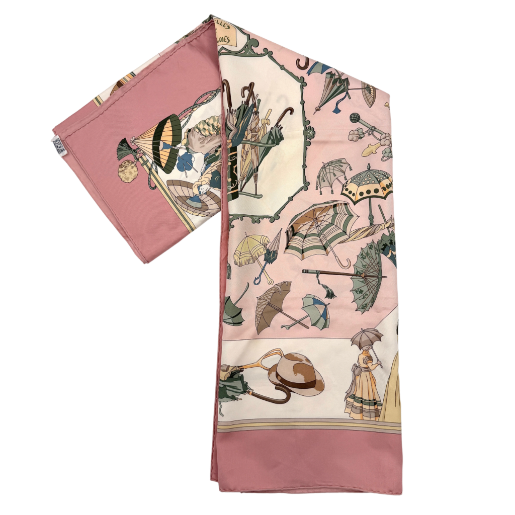 Hermès Ombrelles et Parapluies silk scarf in pink with umbrella print and illustrated figures, gracefully draped to show the intricate design.
