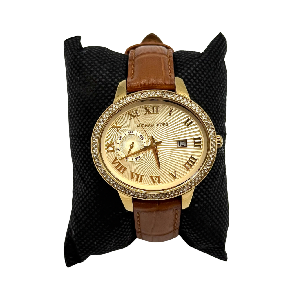 Michael Kors Whitley MK2428 watch with gold dial, crystal bezel and brown leather strap on black cushion