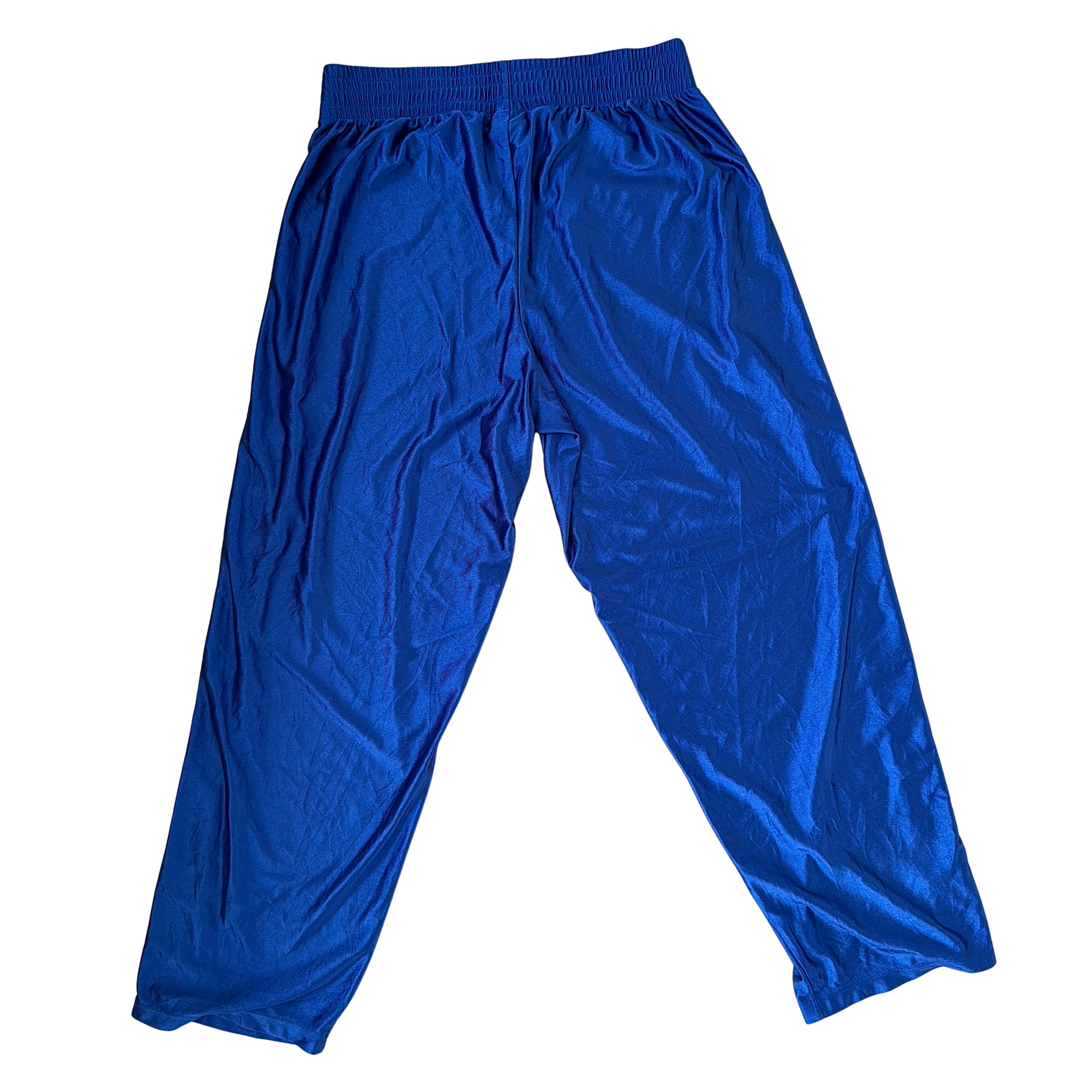 Electric blue Nike tear away track pants with snap button sides and white Swoosh logo displayed flat against a black background.