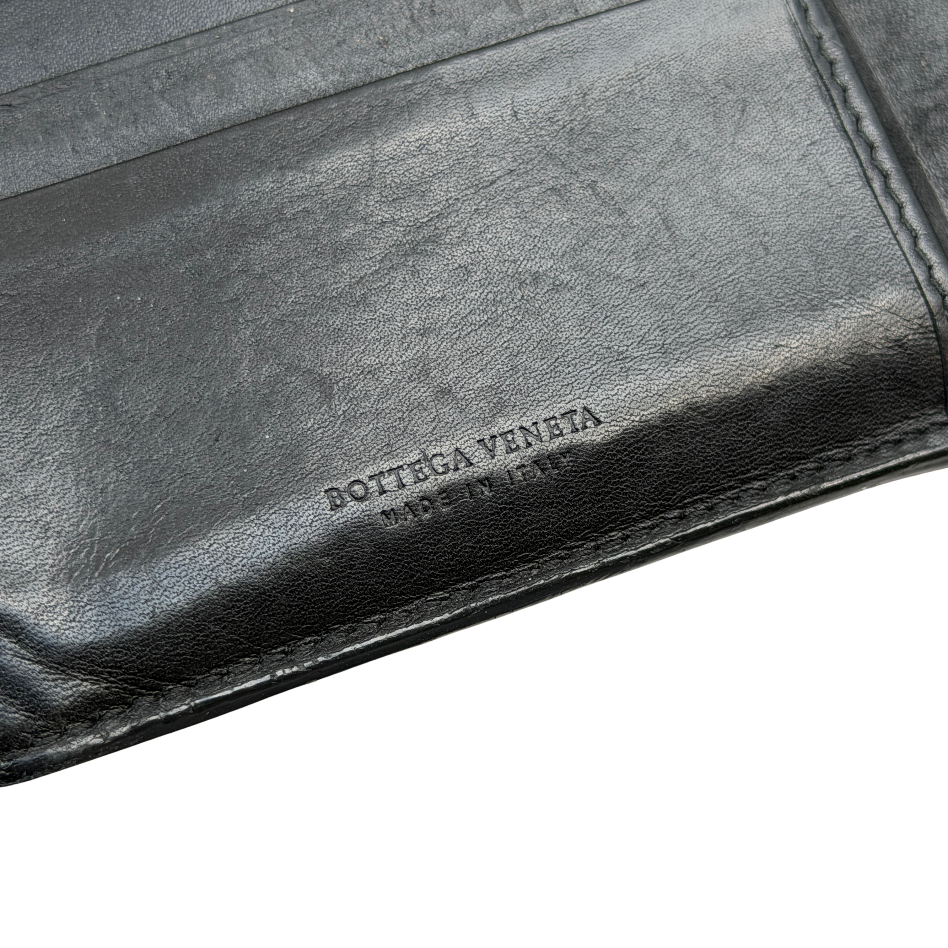 Bottega Veneta Intrecciato wallet in black leather featuring the iconic woven design and a structured rectangular shape.
