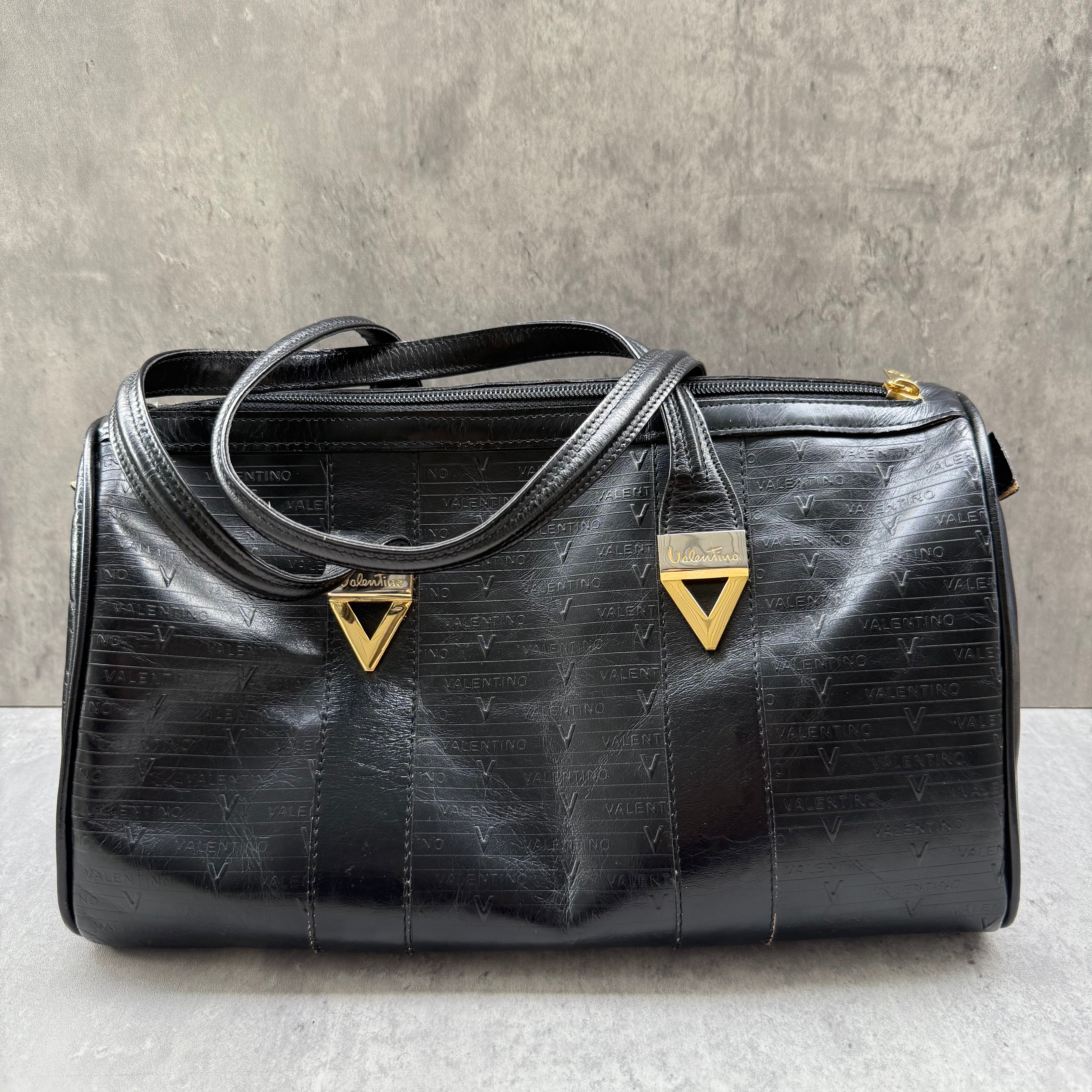Valentino Monogram Boston Bag in glossy black leather with gold triangle logo plates and top handles