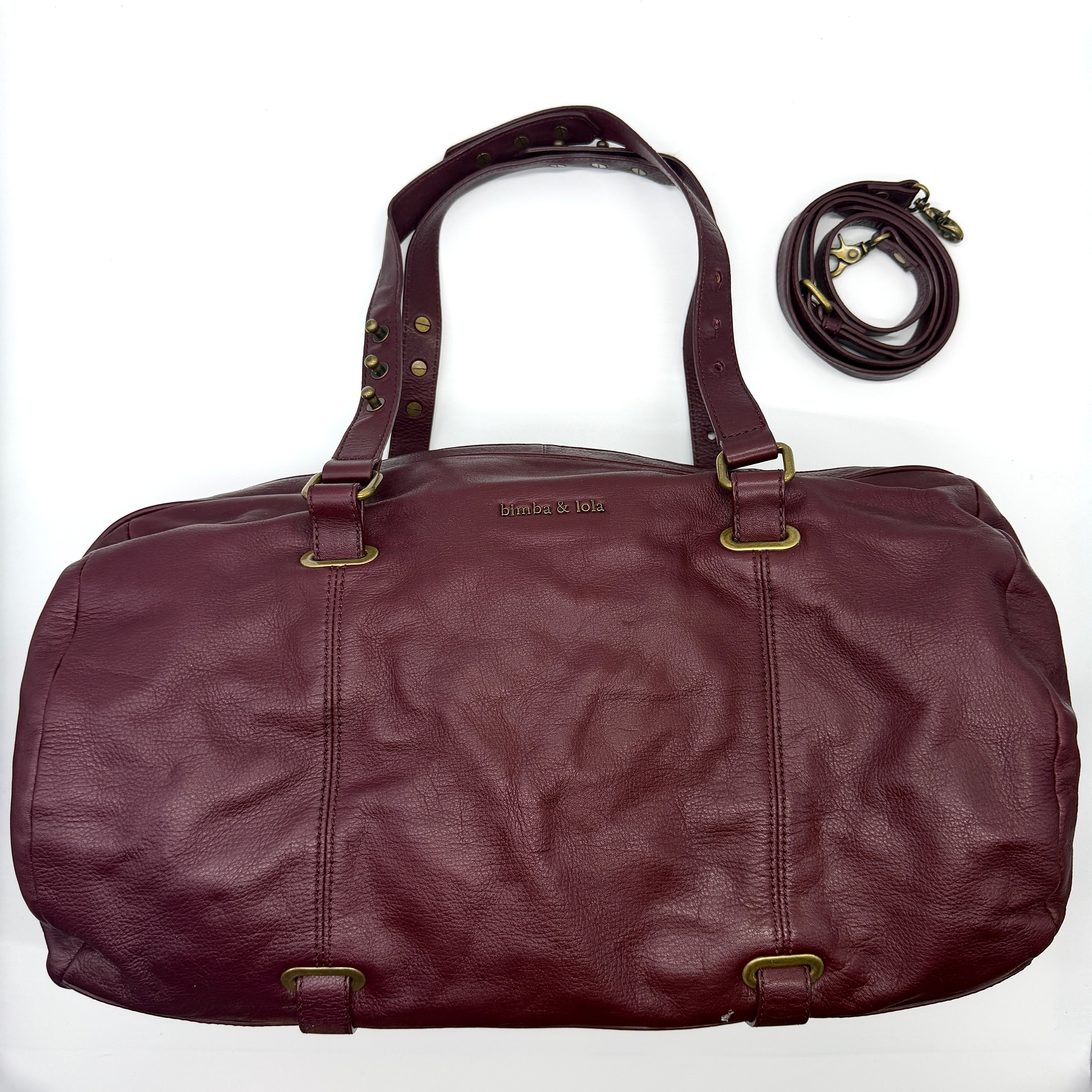 Bimba & Lola 2Way Leather Duffle Bag in burgundy, crafted from leather with antique gold-tone hardware and dual handles.