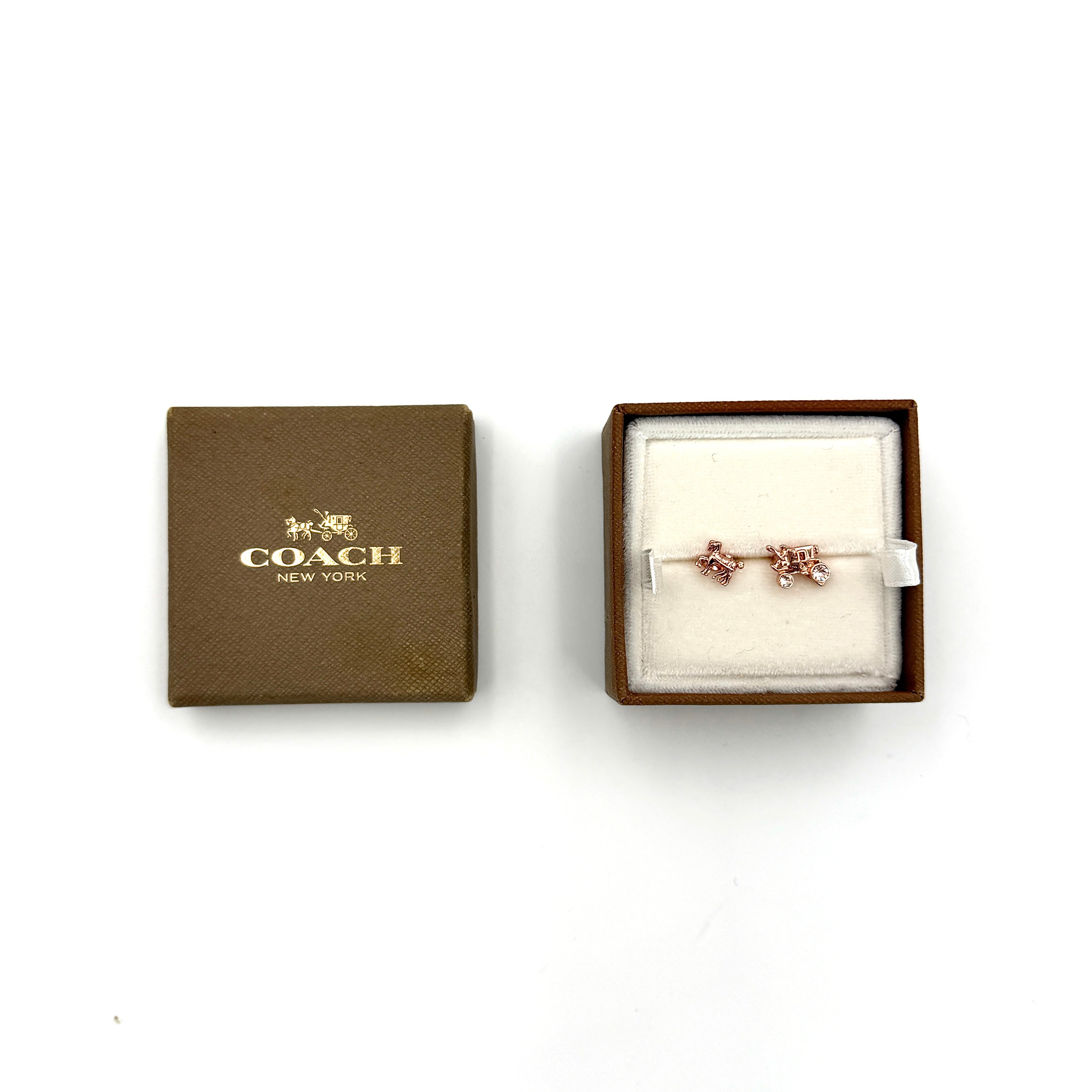 Coach horse and carriage stud earrings in rose gold tone featuring iconic carriage motif with delicate detailing.
