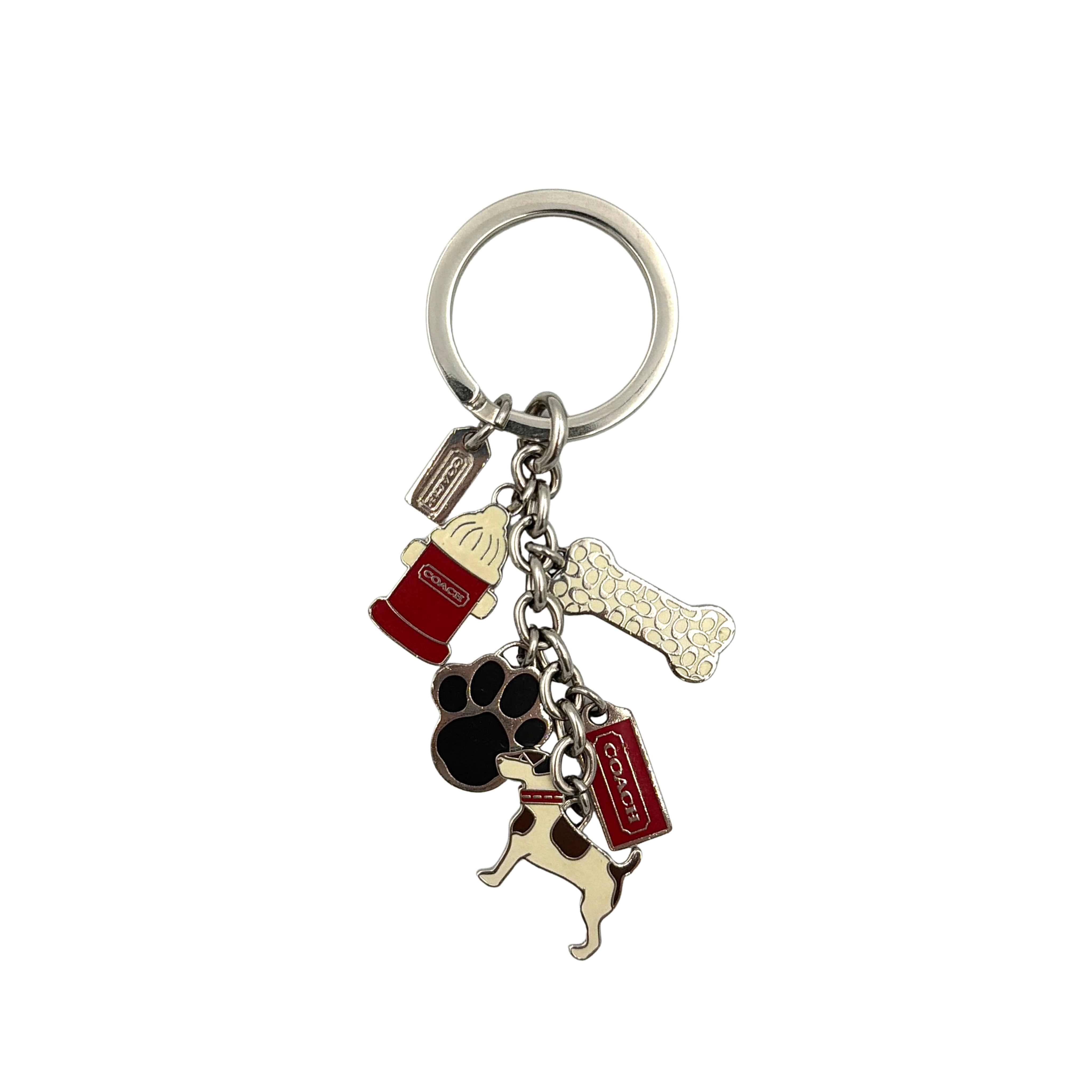 Coach keychain with Jack Russell dog and enamel charm mix in silver-tone hardware, shown with paw print and red accent charms.
