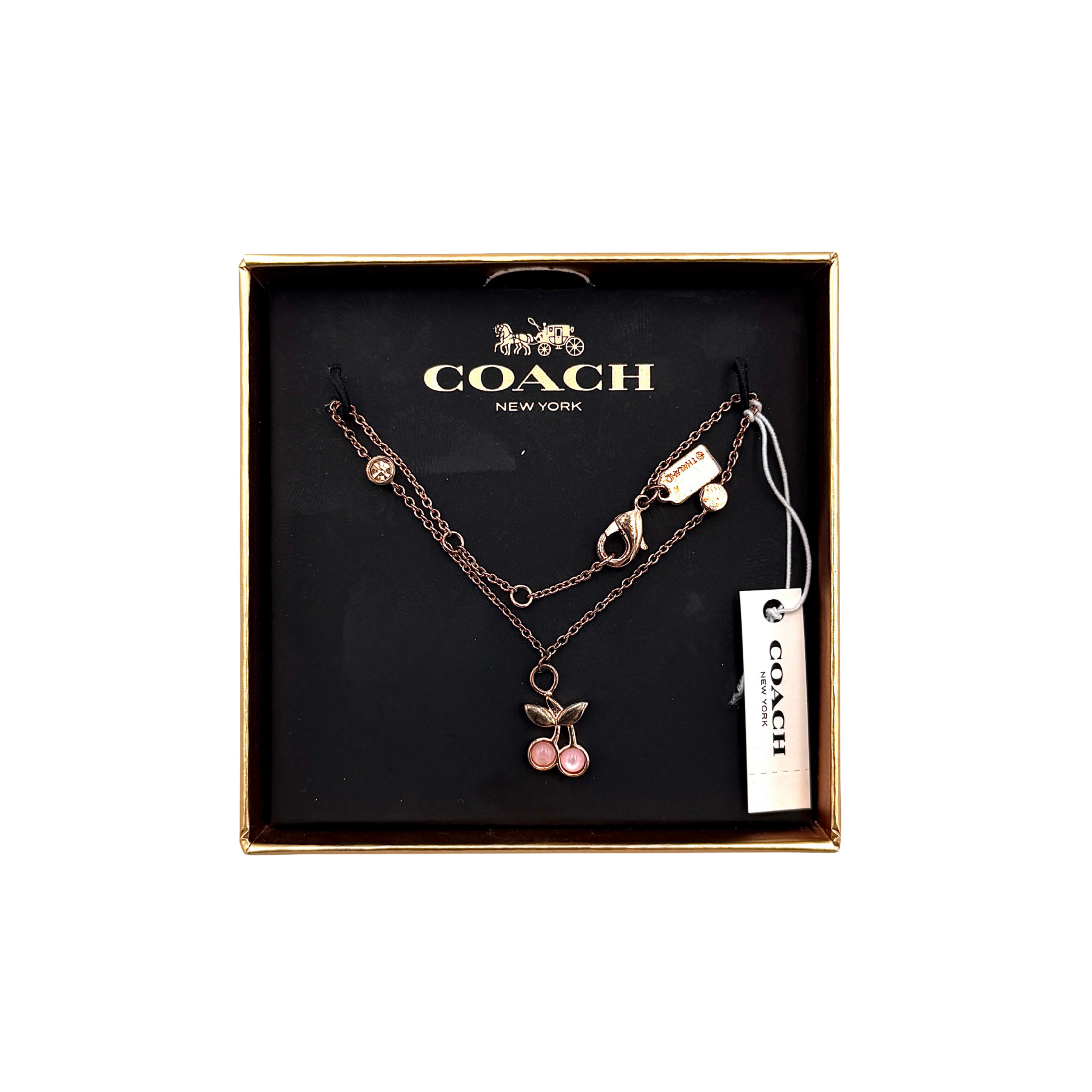 Coach pink cherry necklace in rose gold tone featuring a cherry charm on a fine chain with lobster clasp, shown in Coach box packaging.