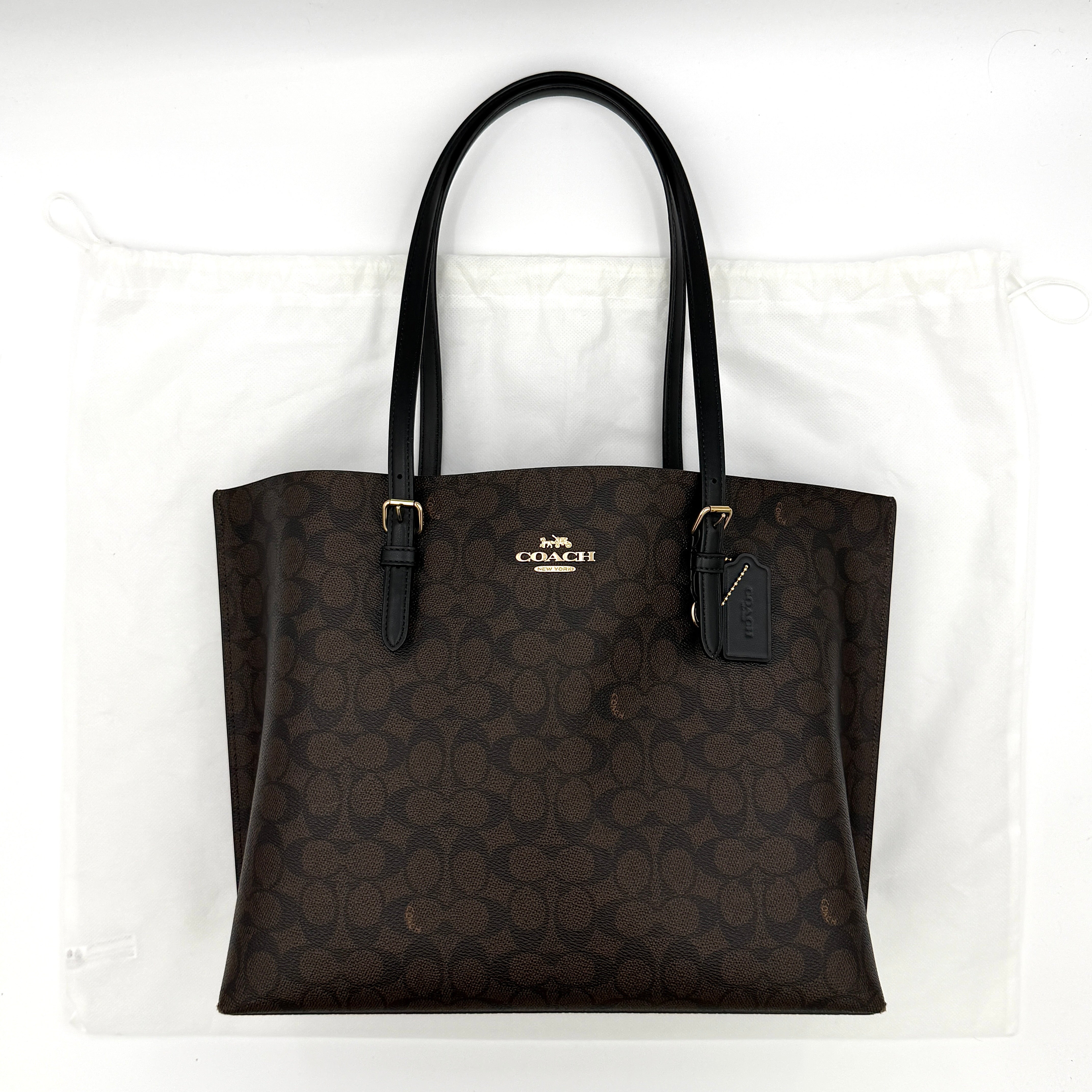 Coach Signature Mollie Tote Bag in brown with black handles, featuring Coach's iconic pattern and discreet logo detail.