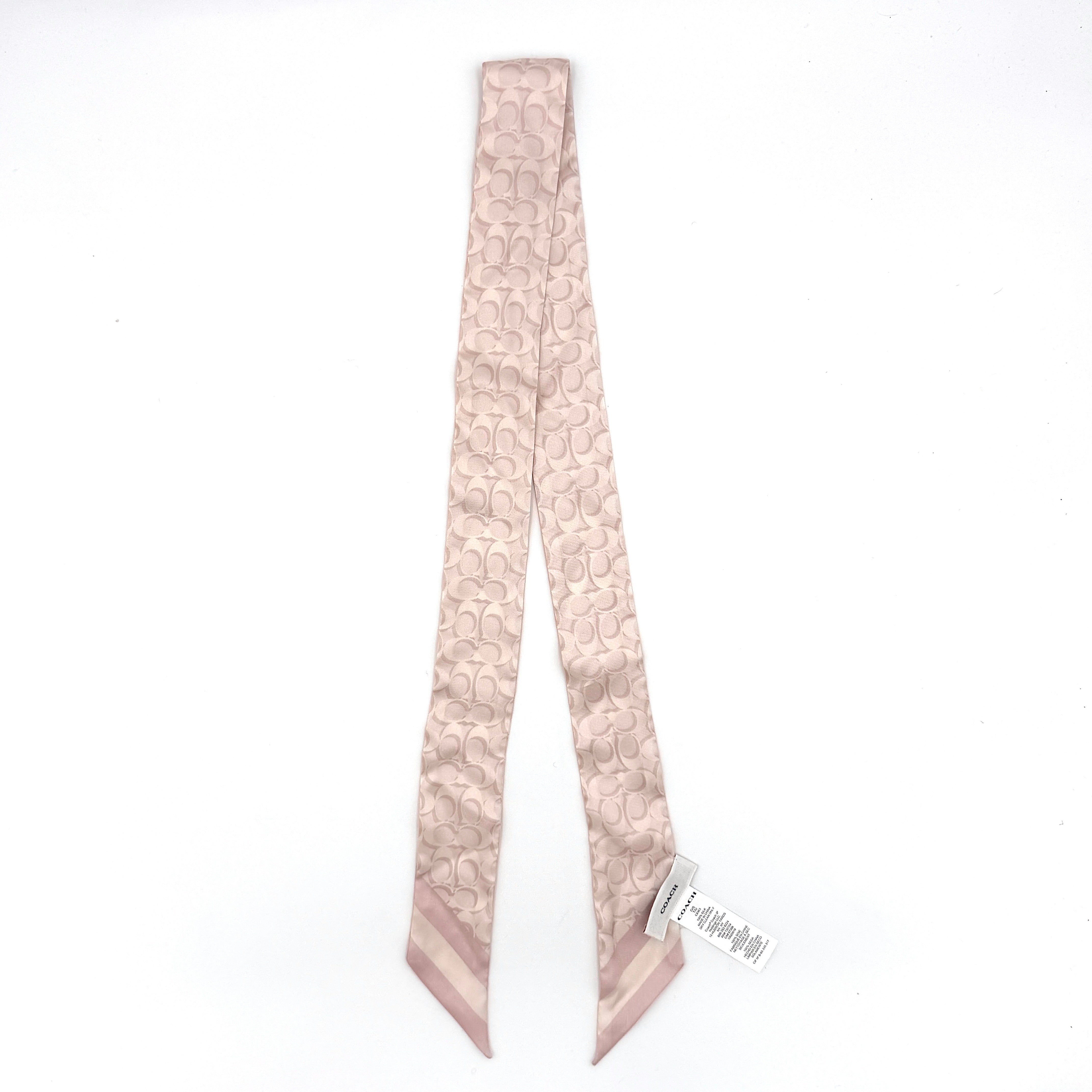 Coach signature print silk skinny scarf in light pink featuring a slim elongated design and iconic Coach pattern.
