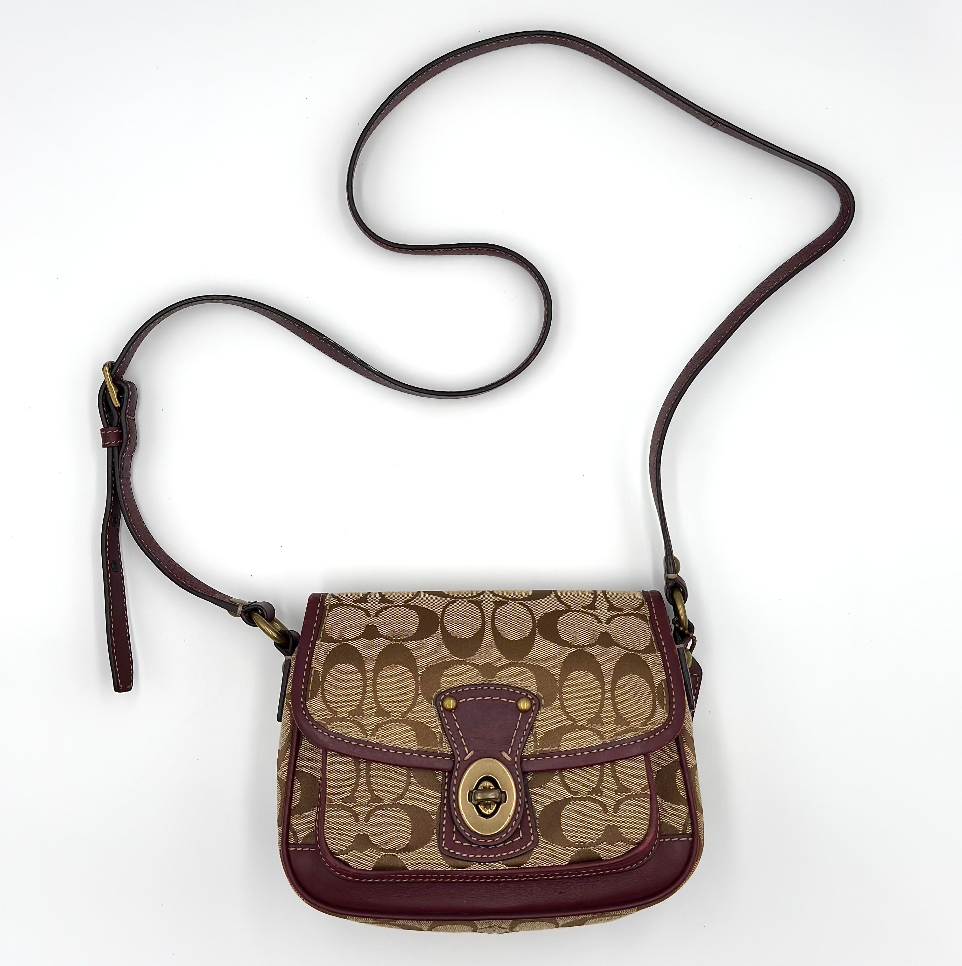 Coach Signature Turnlock Crossbody Bag in beige canvas with purple leather trim, gold-tone hardware, front turn-lock flap, and adjustable crossbody strap.