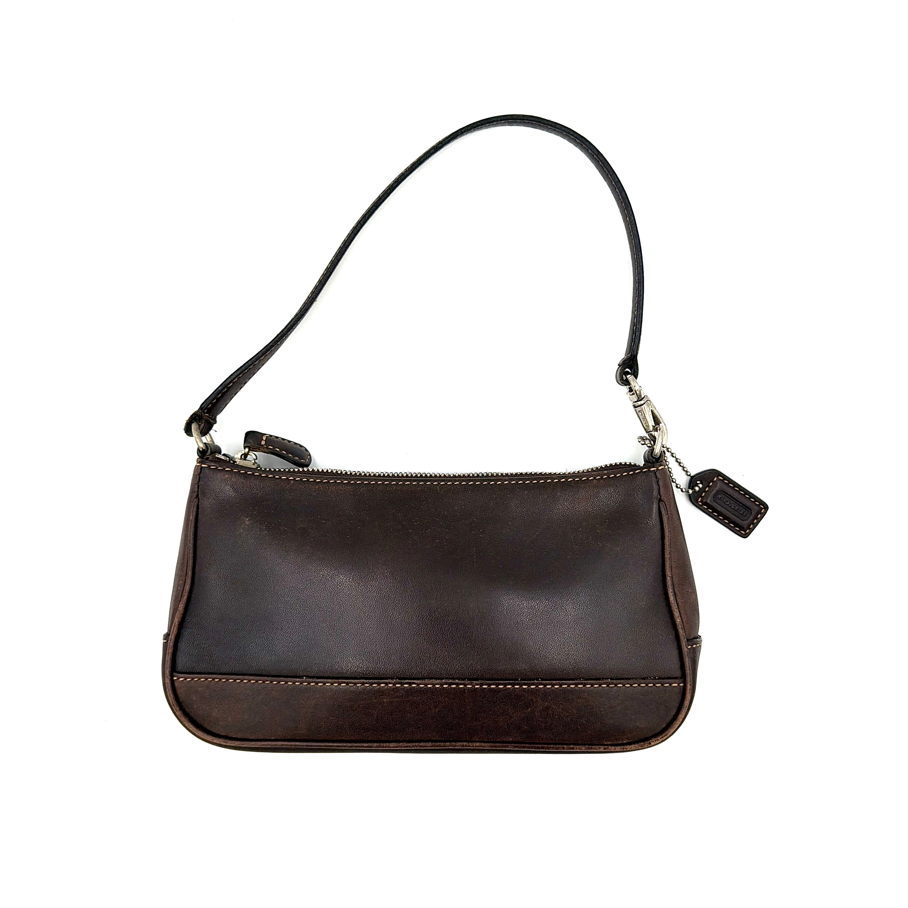 Coach Y2K dark brown leather shoulder bag with a sleek silhouette, featuring a single strap and zip closure.