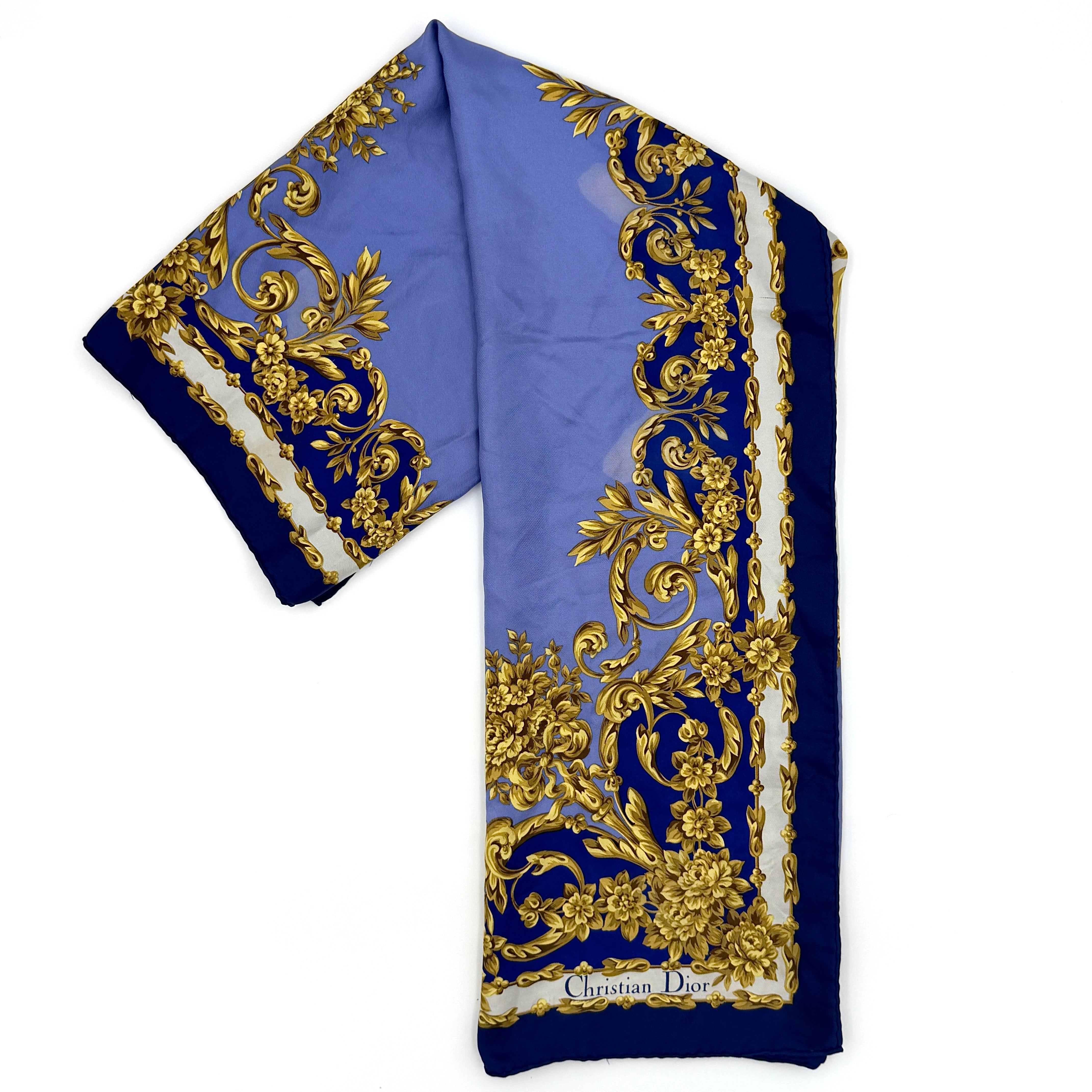 Dior floral silk scarf in blue and gold featuring ornate baroque-style detailing and elegant pattern.
