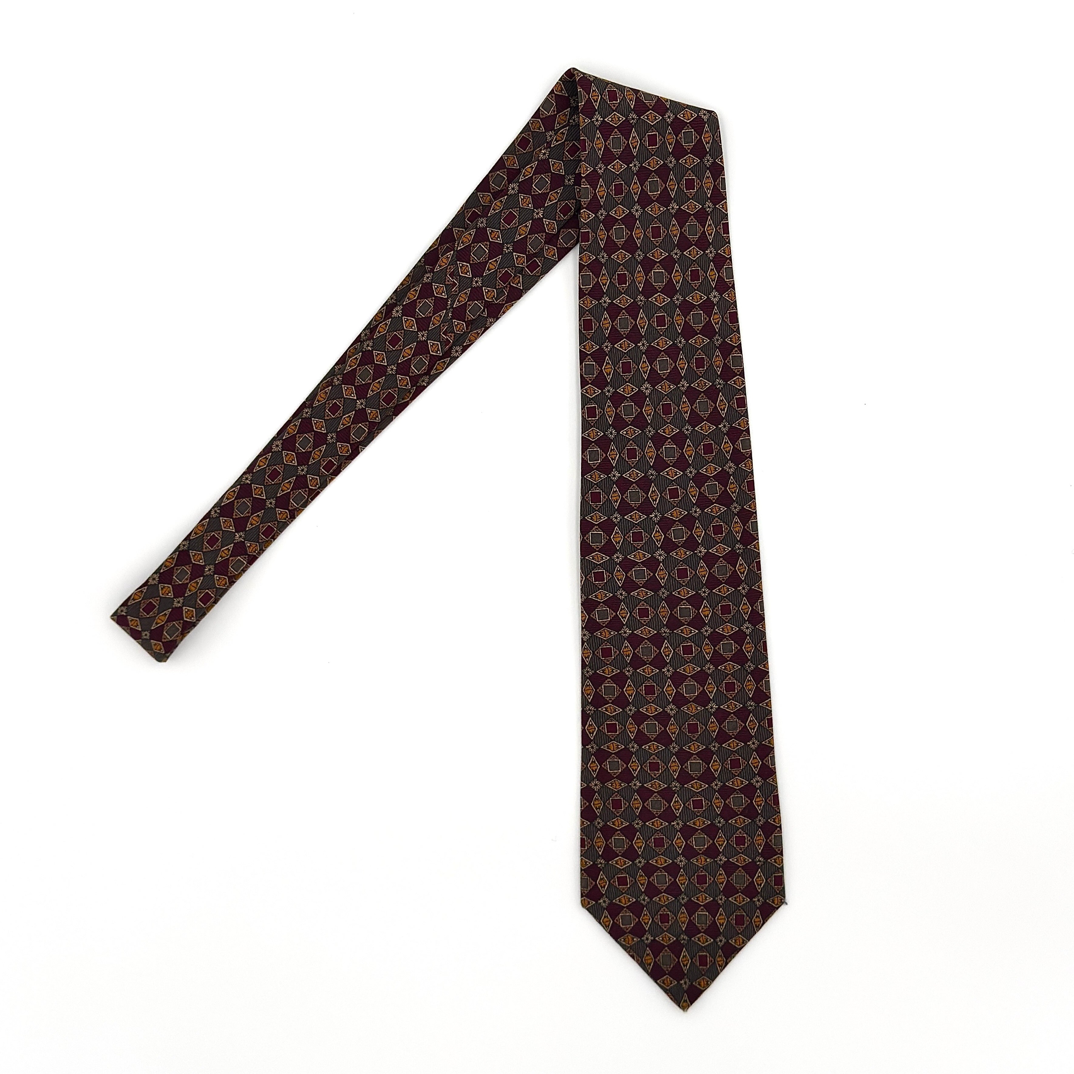 Dior Monsieur multicolor silk paisley tie with geometric pattern in burgundy, brown, and gold tones.