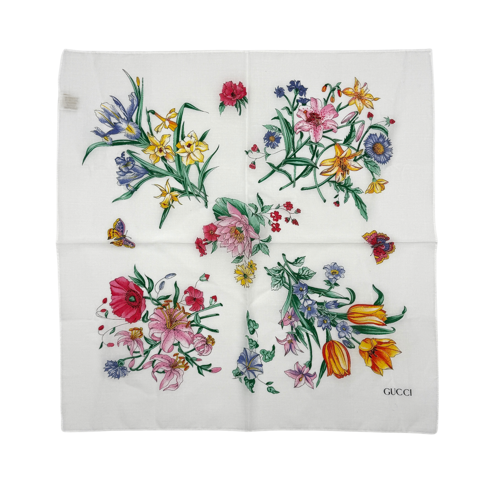 Gucci Flora silk scarf featuring a white background with colorful floral patterns, showcasing intricate detailing and logo.