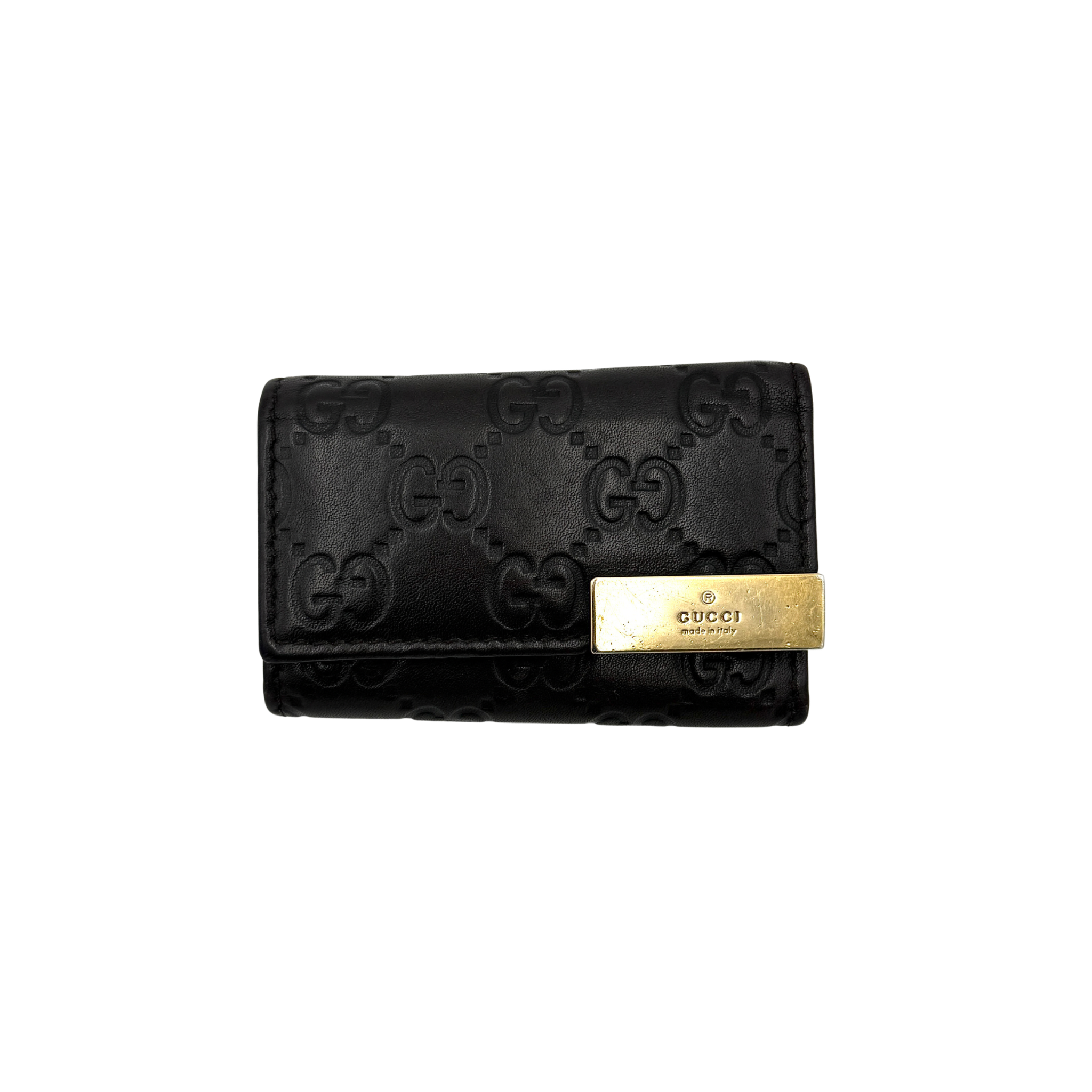 Gucci GG Guccissima black leather key holder with embossed logo pattern, front logo plate, and interior key hooks