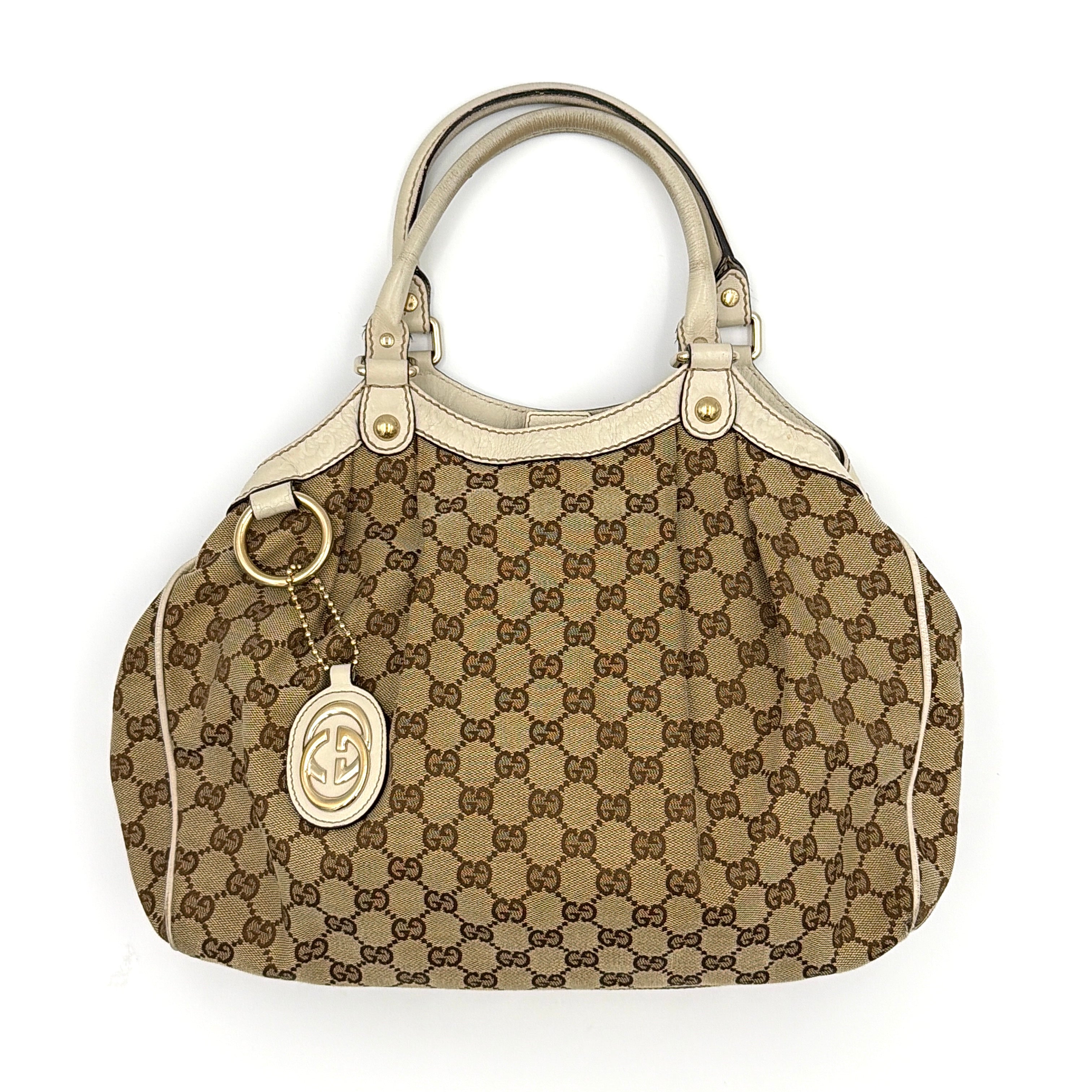 Gucci GG Monogram Sukey Shoulder Bag in beige canvas with white leather trim and gold-tone hardware.