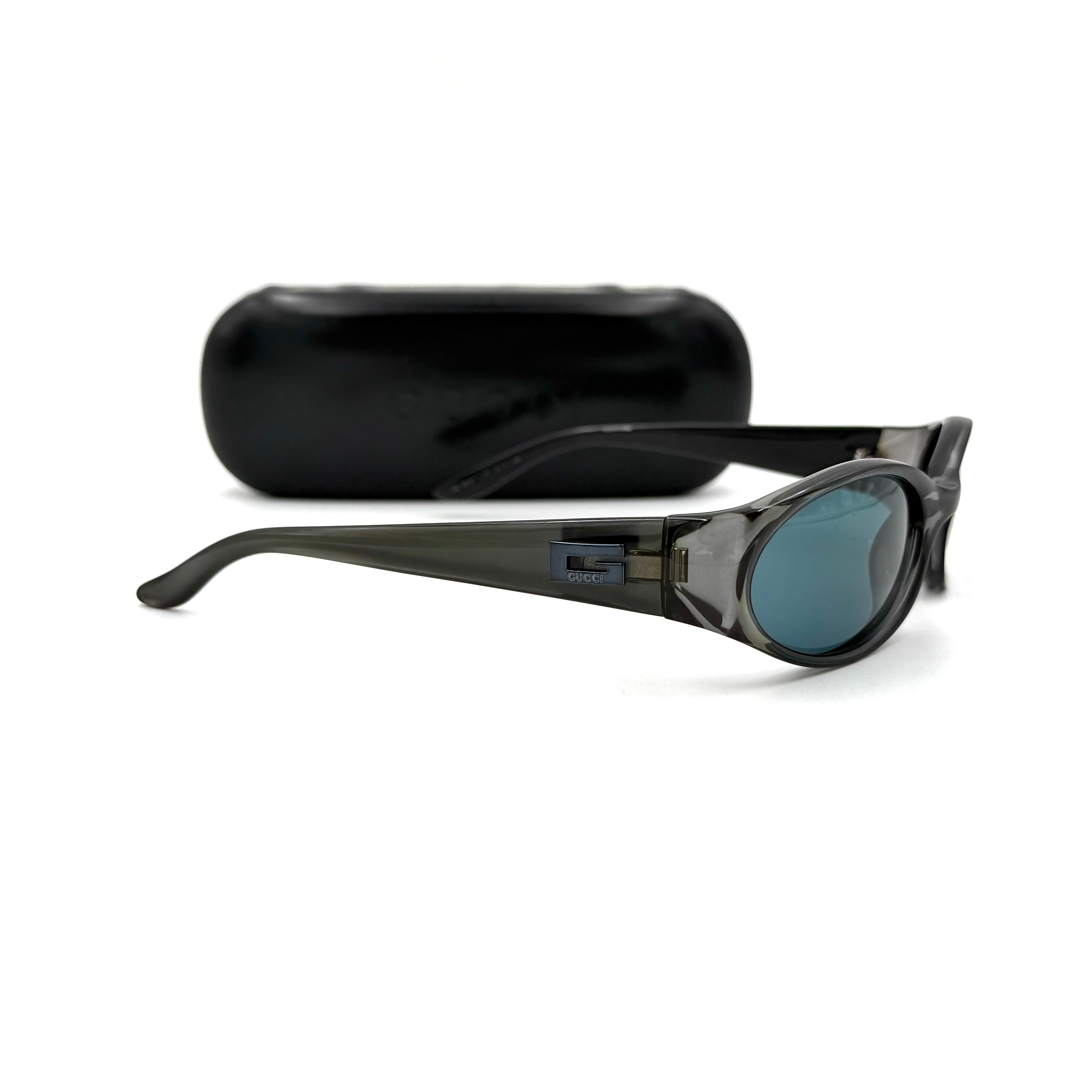 Gucci GG2457/S sunglasses in black with slim oval frame, dark tinted lenses, and Gucci logo detailing.
