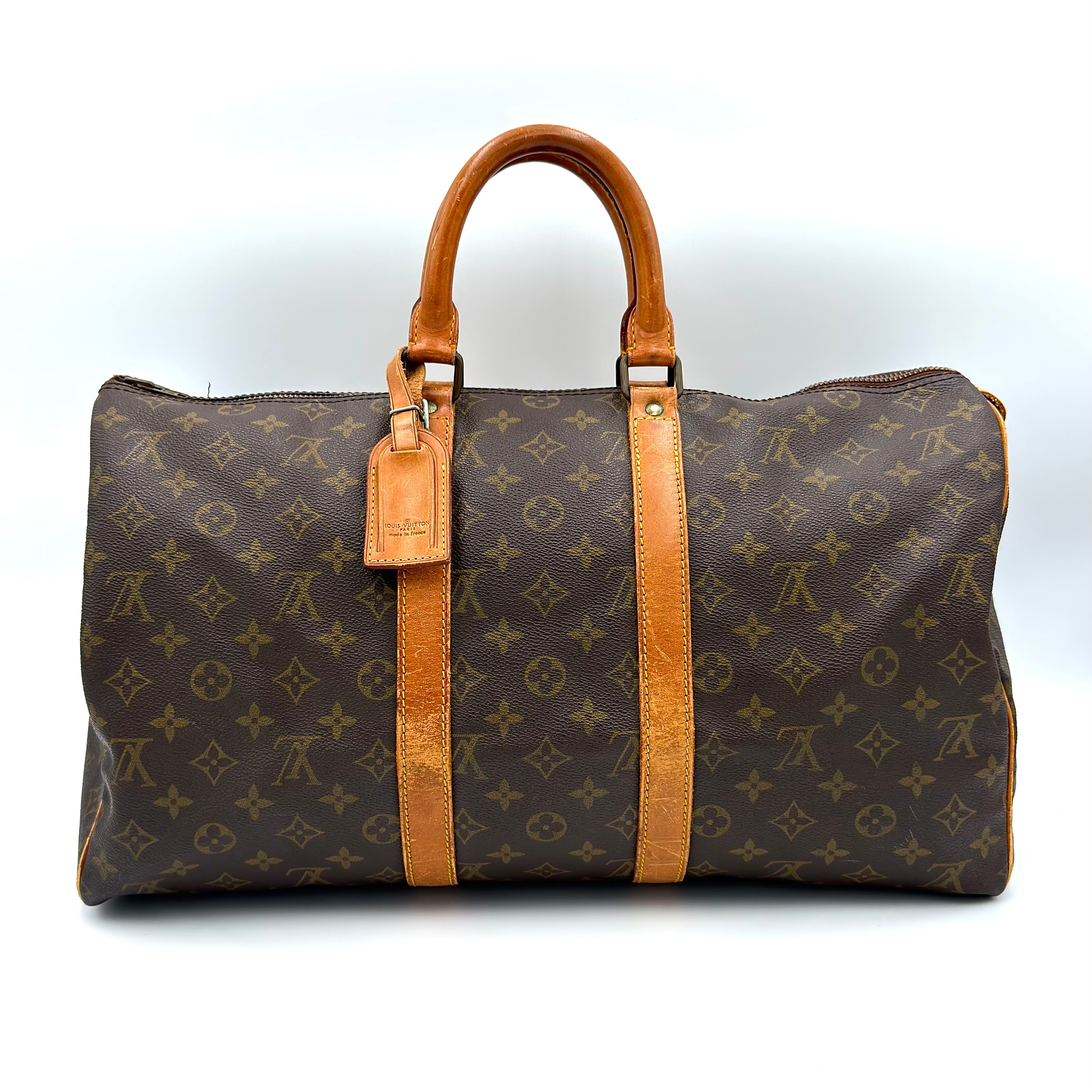 Louis Vuitton Monogram Keepall 45 Duffle Bag in brown coated canvas with natural leather handles and gold-tone hardware.