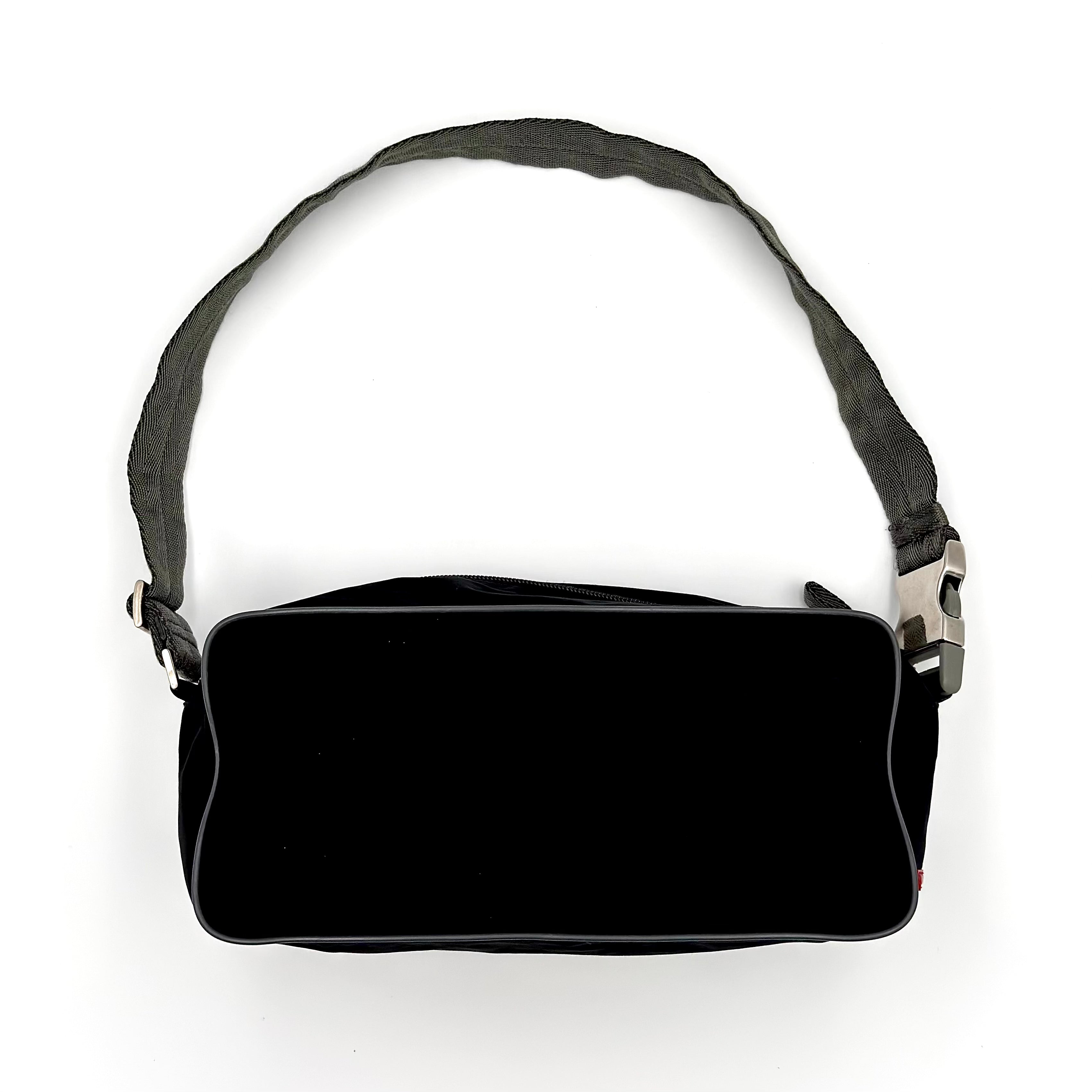 Prada Sport Nylon Shoulder Bag in black with grey canvas strap, featuring red rubber logo tag and silver-tone buckle.